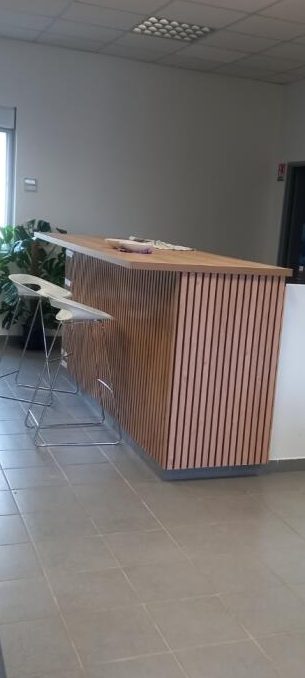 Un comptoir en bois avec des chaises hautes dans un intérieur moderne.